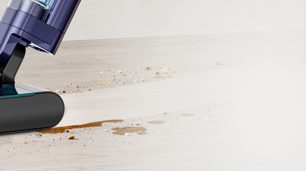 Una aspiradora Hygiene para pisos duros Dyson Clean+Wash limpia un derrame.